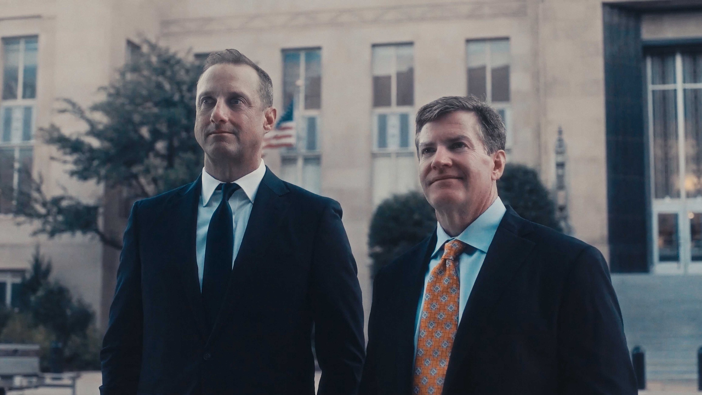 Two attorneys in suits standing outside a courthouse