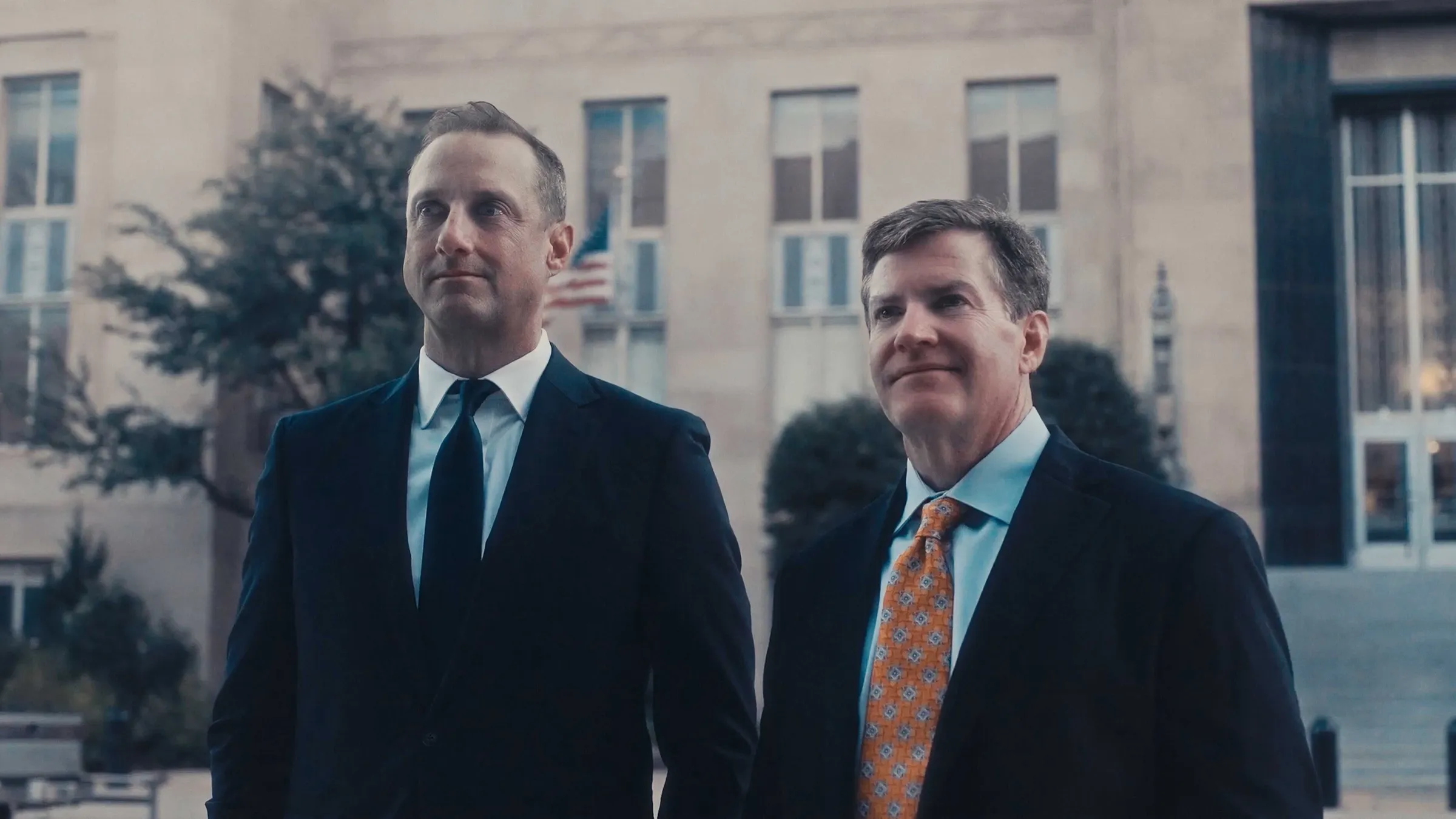 Two attorneys in suits standing outside a courthouse