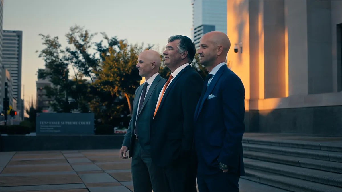 MSB Law brand film thumbnail. Three men in dark suits stand outdoors at dusk in front of a stone building with a sign reading Tennessee Supreme Court visible in the lower left.